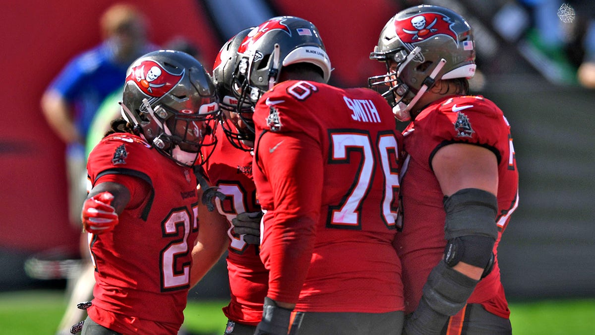 Tampa Bay Buccaneers running back Ronald Jones II (27) celebrates his score against the Minnesota Vikings with teammates, including offensive tackle Donovan Smith (76) during the first half of an NFL football game Sunday, Dec. 13, 2020, in Tampa, Fla. (AP Photo/Jason Behnken)