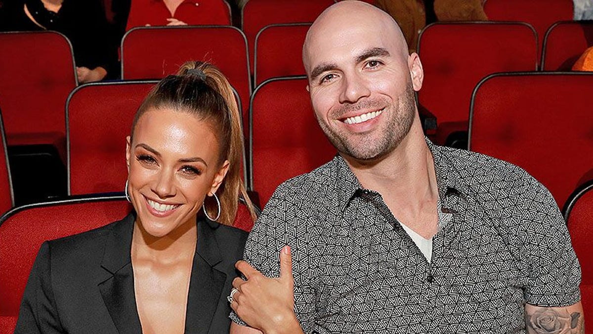 Mike Caussin and Jana Kramer sit in a theater together