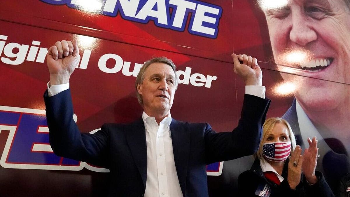 Republican candidate for Senate Sen. David Perdue and his wife, Bonnie, react during a campaign stop at Peachtree Dekalb Airport Monday, Nov. 2, 2020, in Atlanta. (AP Photo/John Bazemore)