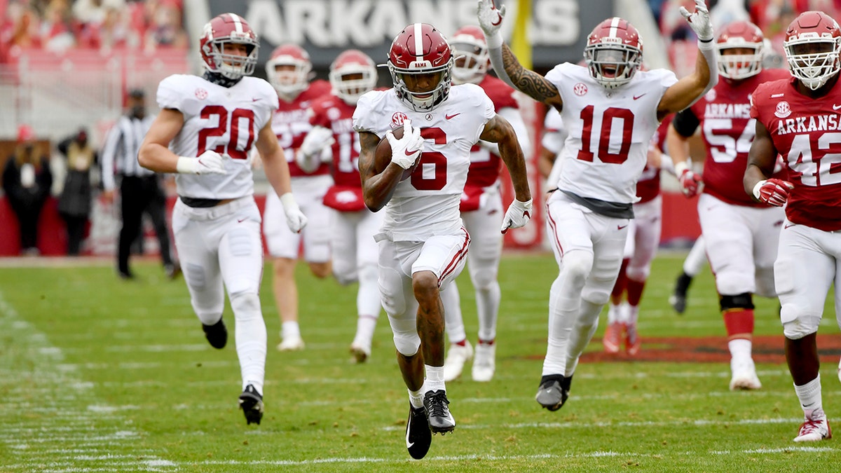 Alabama punt returner DeVonta Smith (6) returns a punt for a touchdown against Arkansas during the first half of an NCAA college football game Saturday, Dec. 12, 2020, in Fayetteville, Ark. (AP Photo/Michael Woods)