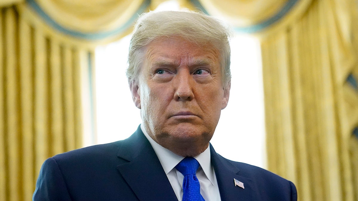 President Trump prepares to award the Presidential Medal of Freedom, the highest civilian honor, to Olympic gold medalist and former University of Iowa wrestling coach Dan Gable in the Oval Office of the White House, Monday, Dec. 7, 2020, in Washington. Trump has threatened to veto the National Defense Authorization Act if it does not include the repeal of Section 230. (AP Photo/Patrick Semansky)