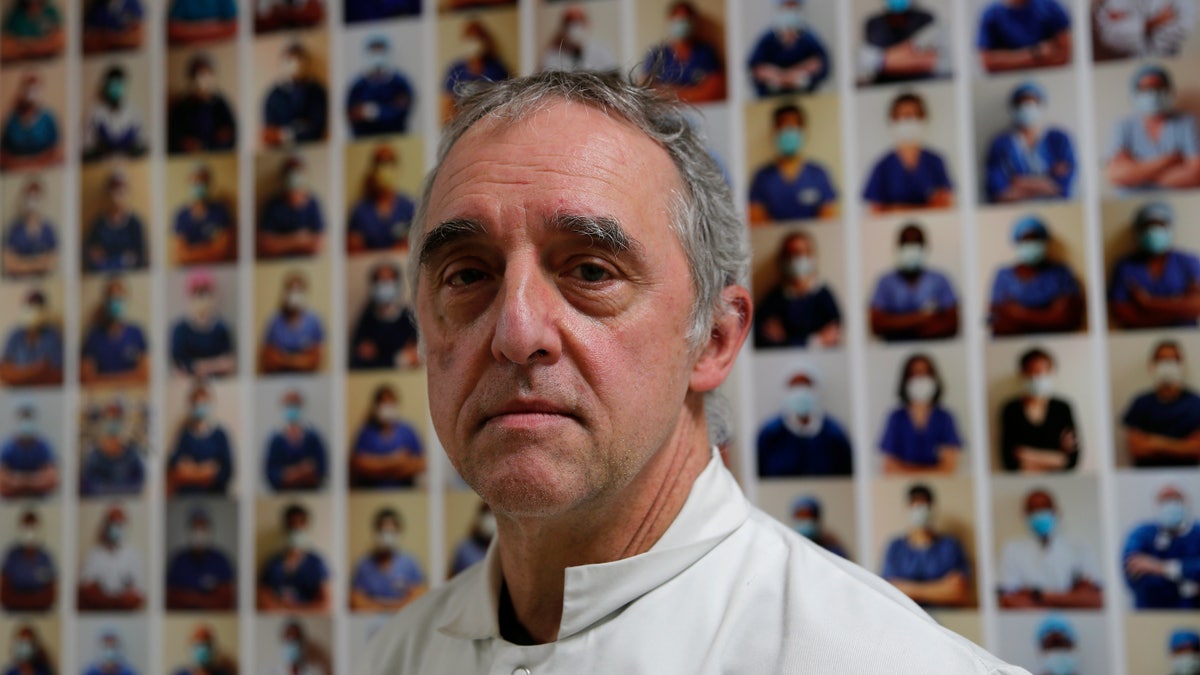 Dr. Philippe Montravers poses in front of a collection of portraits of medical staff at Bichat Hospital, AP-HP, in Paris. 