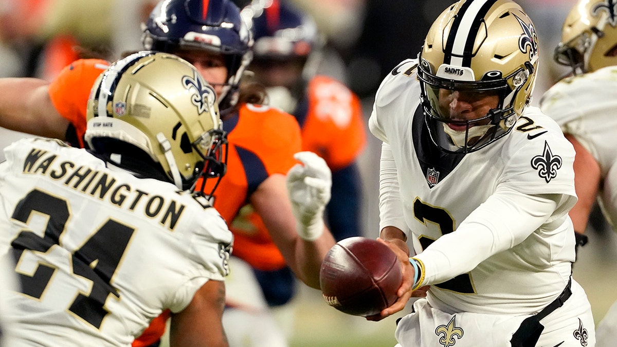 New Orleans Saints quarterback Jameis Winston (2) hands off to running back Dwayne Washington (24) during the second half of an NFL football game against the Denver Broncos, Sunday, Nov. 29, 2020, in Denver. (AP Photo/Jack Dempsey)