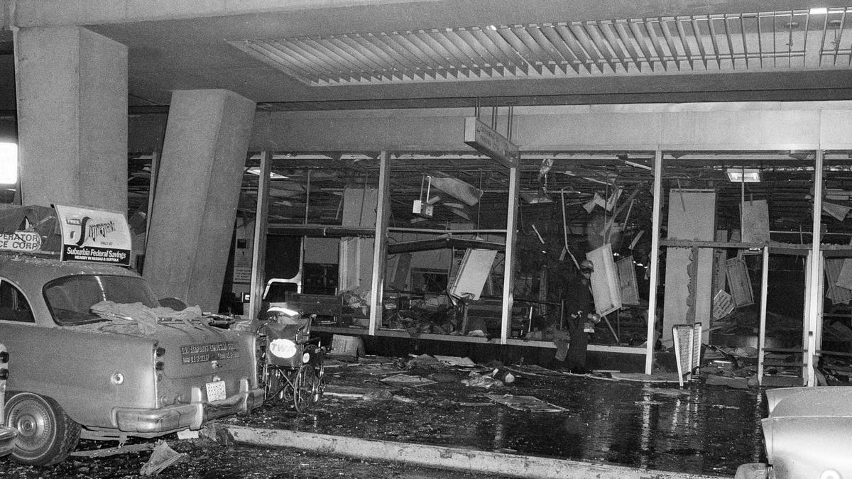 A solitary police rescue officer scans debris at New York's La Guardia Airport, Dec. 29, 1975, after a power explosion demolished a terminal baggage claim area. At least 11 persons were killed. (AP Photo)