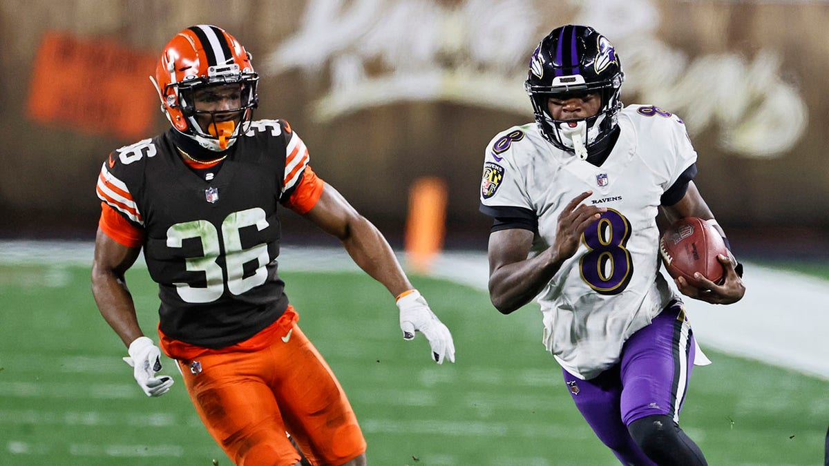 Baltimore Ravens quarterback Lamar Jackson (8) scrambles under pressure from Cleveland Browns cornerback M.J. Stewart Jr. (36) during the second half of an NFL football game, Monday, Dec. 14, 2020, in Cleveland. (AP Photo/Ron Schwane)