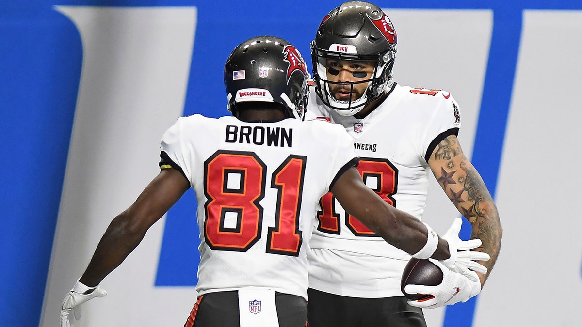 Tampa Bay Buccaneers wide receiver Mike Evans (13) celebrates his 27-yard reception for a touchdown with teammate wide receiver Antonio Brown (81) during the first half of an NFL football game against the Detroit Lions, Saturday, Dec. 26, 2020, in Detroit. (AP Photo/Lon Horwedel)