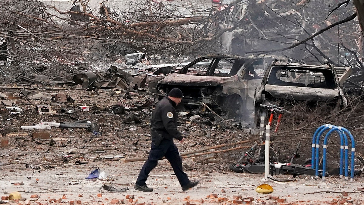 A law enforcement member walks past damage from an explosion in downtown Nashville, Tenn., Friday, Dec. 25, 2020. Buildings shook in the immediate area and beyond after a loud boom was heard early Christmas morning. (AP Photo/Mark Humphrey)