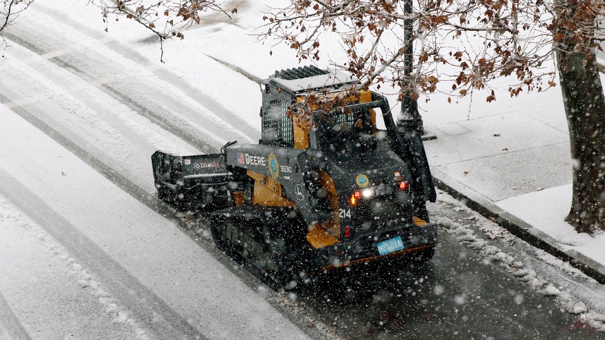 A snow clearing machine cleans a road during heavy snow, Saturday, Dec. 5, 2020, in Marlborough, Mass.