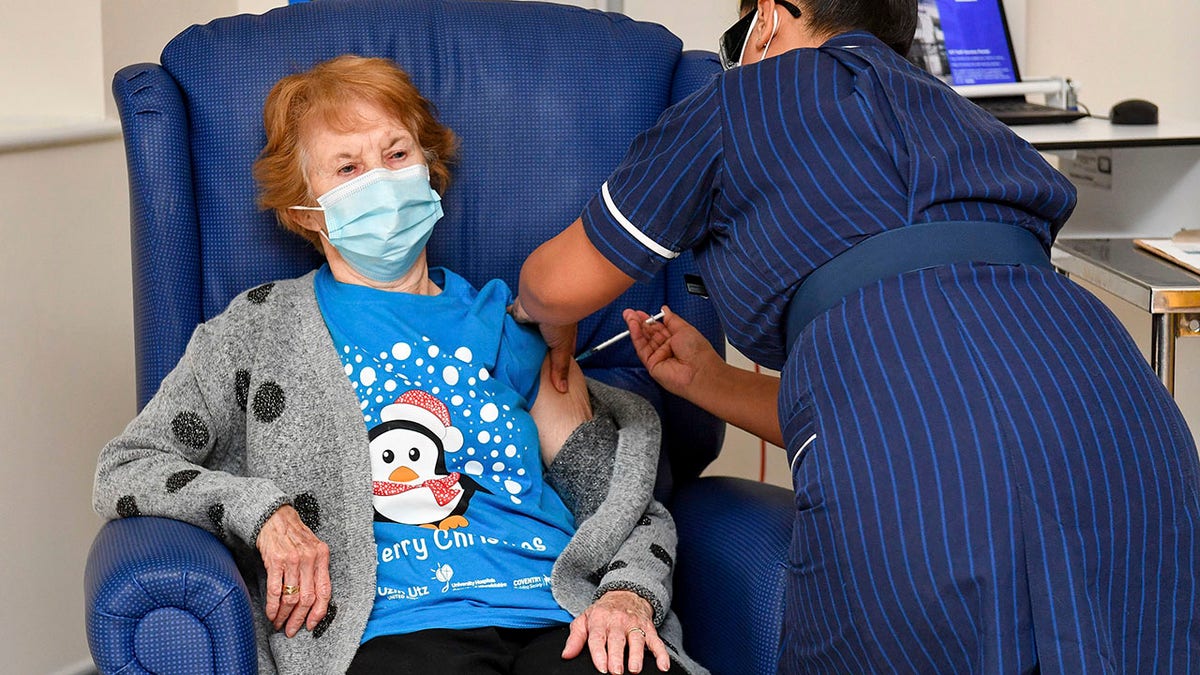 Margaret Keenan, 90, the first patient in the UK to receive the Pfizer-BioNTech COVID-19 vaccine, administered by nurse May Parsons at University Hospital, Coventry, England, Tuesday Dec. 8, 2020.  (Jacob King/Pool via AP)