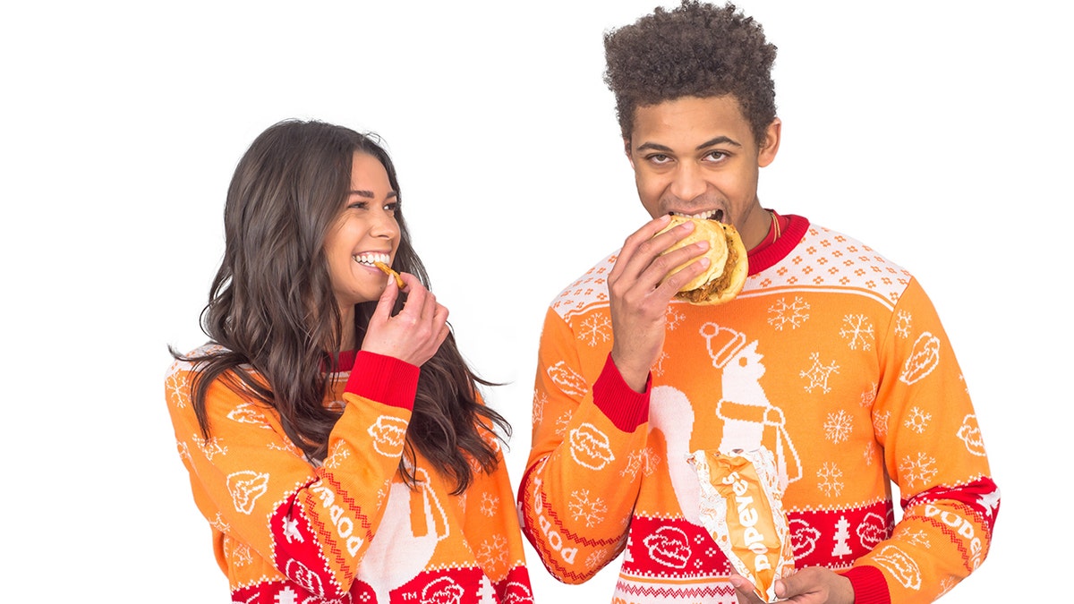 It is not a requirement to eat a chicken sandwich while wearing a Popeyes sweater. But it does look fun.