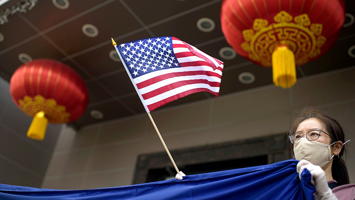 A protester holds a U.S. flag outside the Chinese consulate in Houston, July 24, 2020, after the U.S. State Department ordered China to close the consulate. (Getty Images)