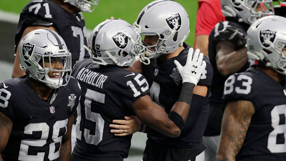 Las Vegas Raiders quarterback Derek Carr, center right, embraces wide receiver Nelson Agholor (15) after Agholor made a touchdown catch against the Indianapolis Colts during the first half of an NFL football game, Sunday, Dec. 13, 2020, in Las Vegas. (AP Photo/Isaac Brekken)