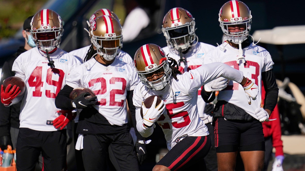 San Francisco 49ers cornerback Richard Sherman takes off with the ball during NFL football practice near State Farm Stadium, home of the Arizona Cardinals, Thursday, Dec. 3, 2020, in Glendale, Ariz. The 49ers are on a three-week road trip after being forced from their stadium and practice facility because of strict new COVID-19 protocols in their home county in Northern California. (AP Photo/Ross D. Franklin)