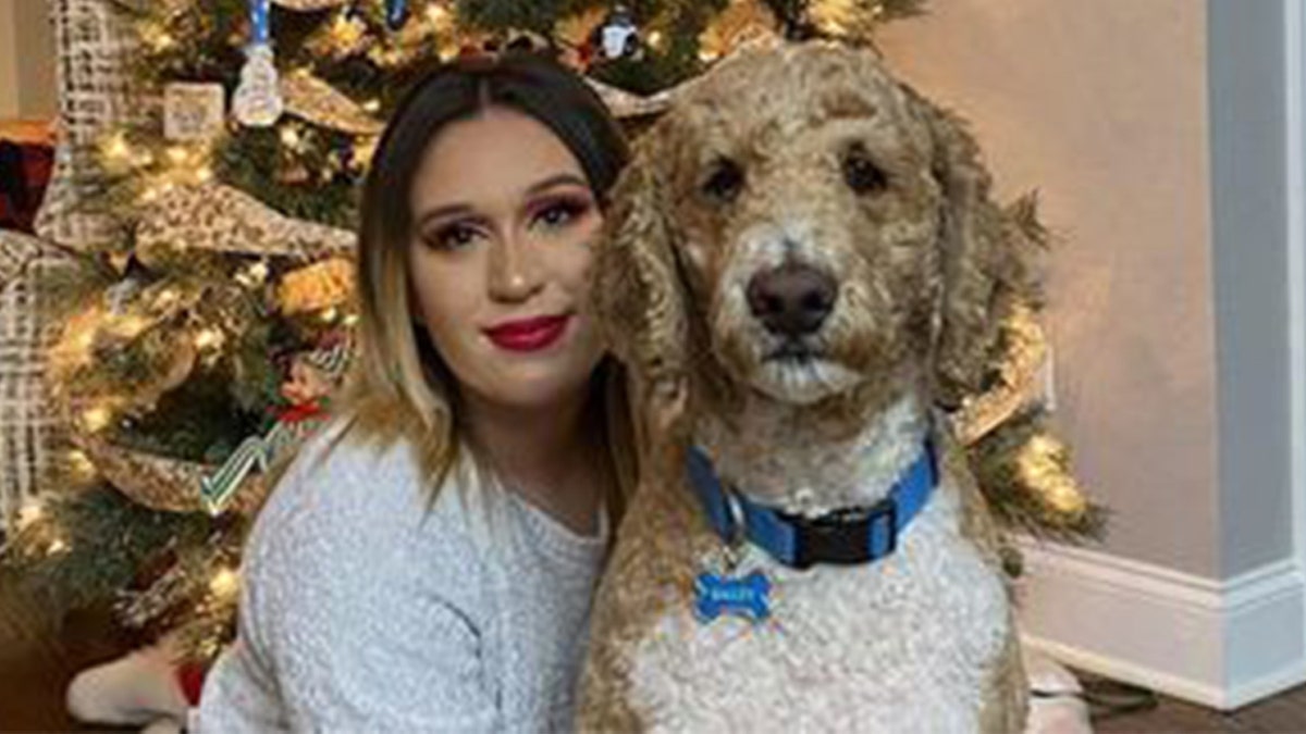 Sarah Simental posing for a Christmas photo with her dog.
