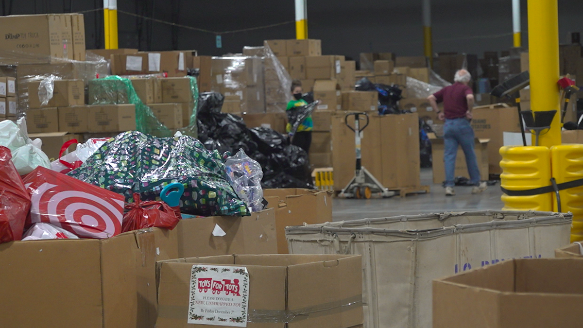 Two volunteers working to sort and prepare toys for children at the Toys for Tots distribution center. Source: Fox News