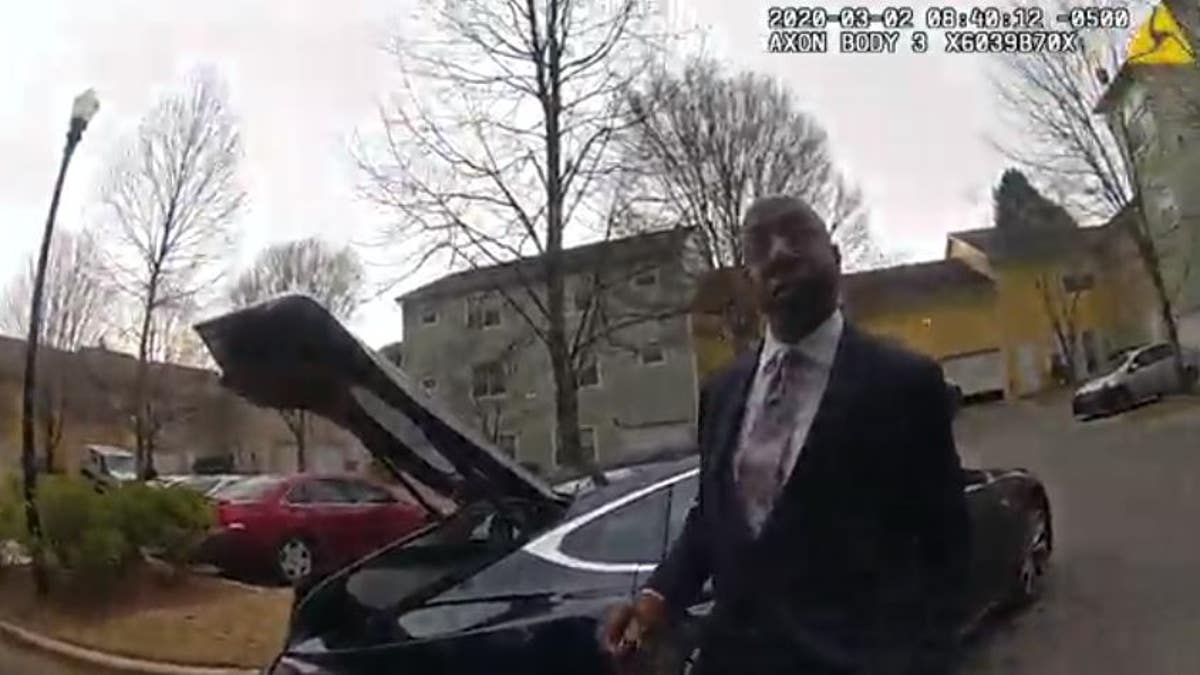 Rev. Raphael Warnock speaking with a police officer after a dispute with his estranged wife. 