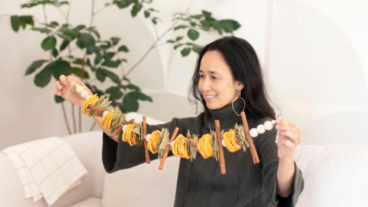 San Francisco Bay-area based Mariam Naficy, shown here, founder of online design marketplace Minted, has been making garlands this year out of various materials, including fragrant dried orange slices. (Minted via AP)
