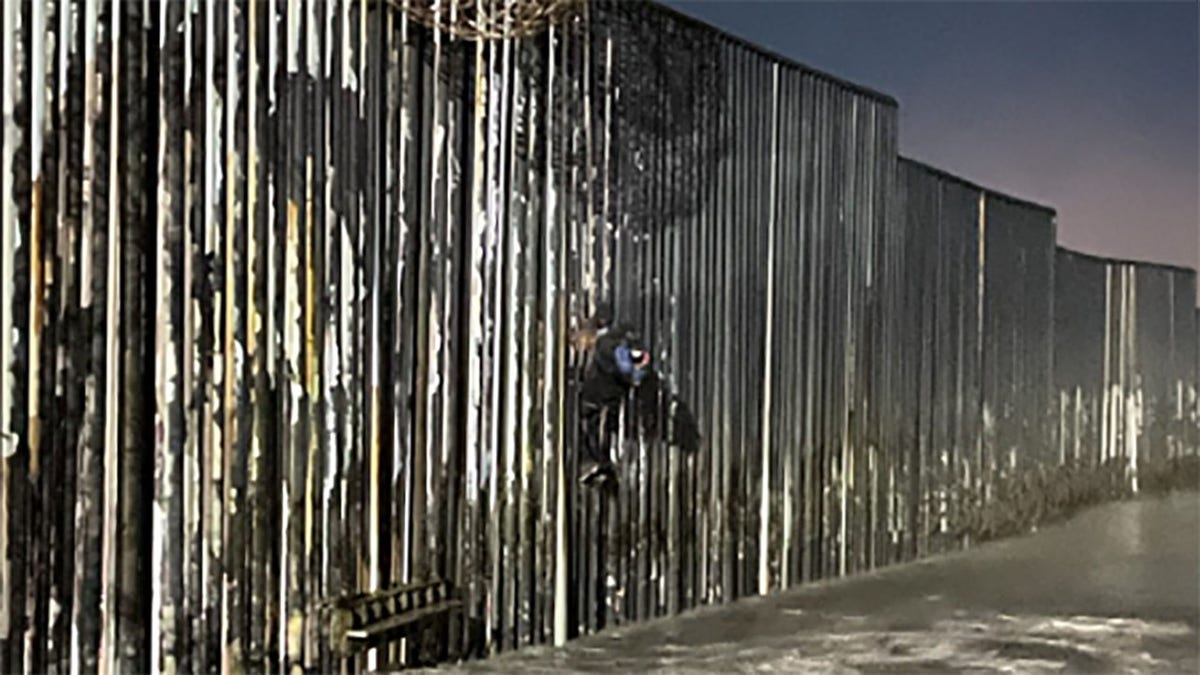 The 25-year-old Mexican national spotted hanging from a part of the wall that jutted into the Pacific Ocean, the agency said.