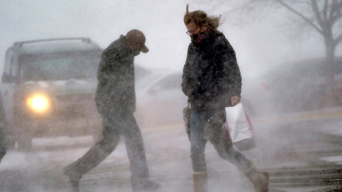 A shopper returns to her vehicle in blowing snow in Omaha, Neb., Wednesday, Dec. 23, 2020. (AP Photo/Nati Harnik)