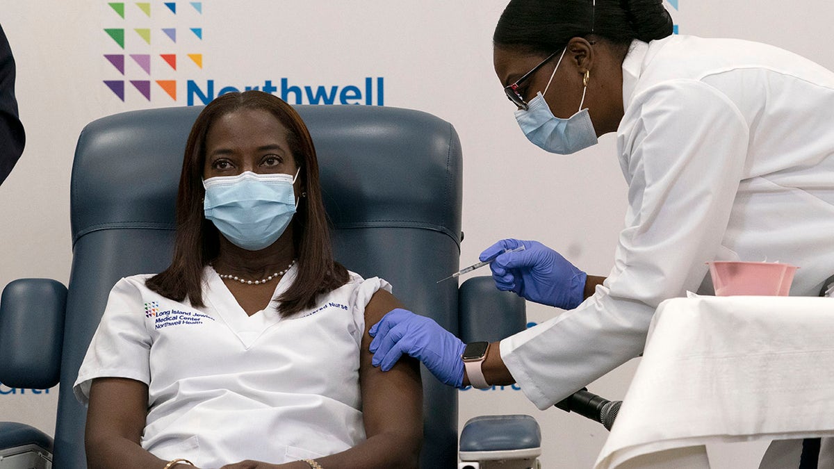 Sandra Lindsay, left, a nurse at Long Island Jewish Medical Center, is inoculated with the Pfizer-BioNTech COVID-19 vaccine by Dr. Michelle Chester, Monday, Dec. 14, 2020, in the Queens borough of New York. (AP Photo/Mark Lennihan, Pool)