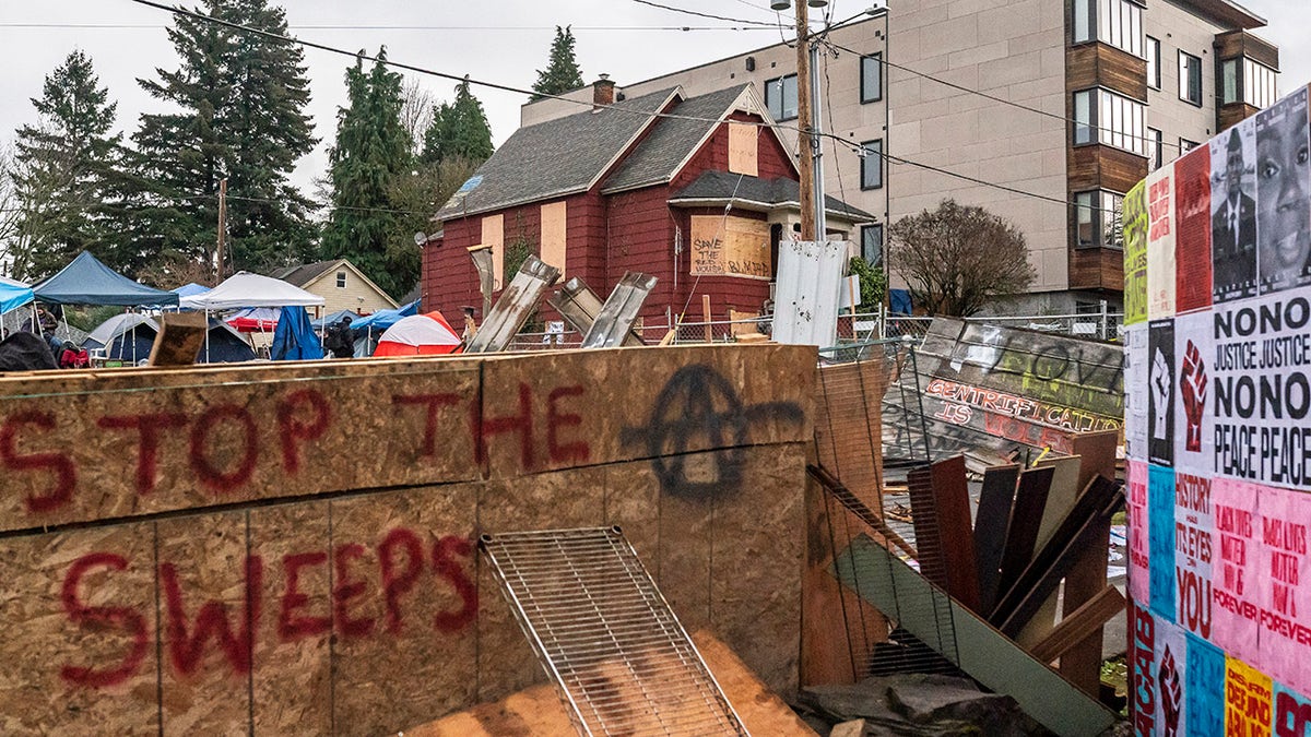 PORTLAND, OR - DECEMBER 09: Layers of chainlink fence and wood block the entry to the Red House on Mississippi Street on December 9, 2020 in Portland, Oregon. Police and protesters clashed during an attempted eviction Tuesday morning, leading protesters to establish a barricade around the Red House. (Photo by Nathan Howard/Getty Images)