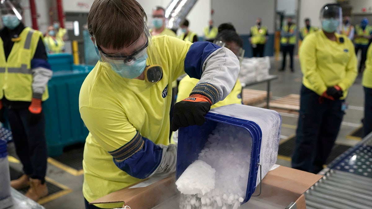 Dry ice is poured into a box containing the Pfizer-BioNTech COVID-19 vaccine as it is prepared to be shipped at the Pfizer Global Supply Kalamazoo manufacturing plant in Portage, Mich., Sunday, Dec. 13, 2020.