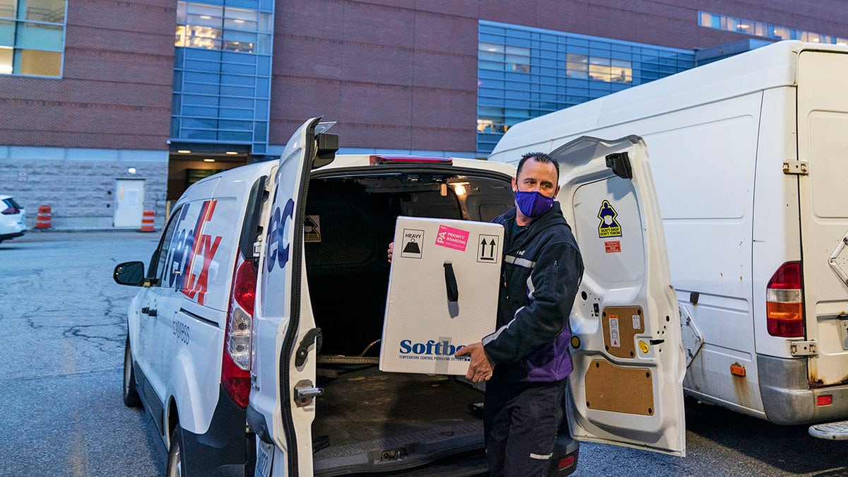 A FedEx driver delivers a box containing the Pfizer-BioNTech COVID-19 vaccine to Rhode Island Hospital in Providence, R.I., Monday, Dec. 14, 2020. (AP Photo/David Goldman)