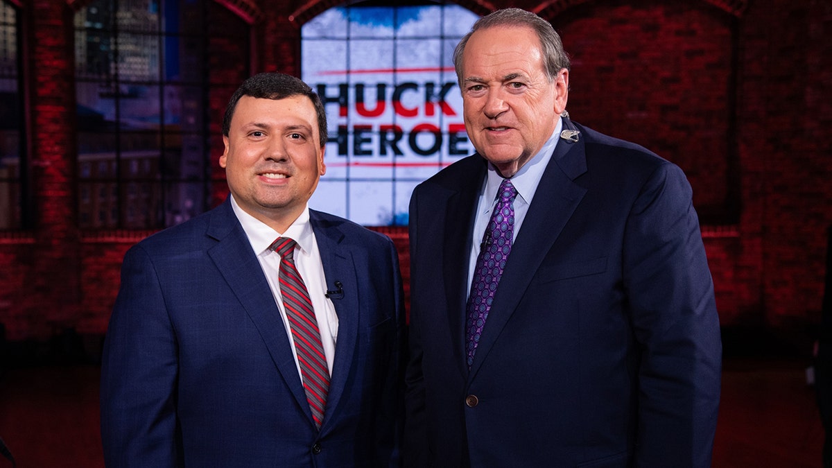 Xavier DeGroat, a Michigan student, with former Gov. Mike Huckabee. DeGroat was honored as a "hero" on Huckabee's show in 2020.
