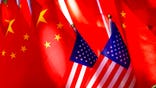 FILE - In this Sept. 16, 2018, file photo, American flags are displayed together with Chinese flags on top of a trishaw in Beijing. China on Thursday, Dec. 3, 2020 accused critics in the U.S. government of "an escalation of political suppression" against Beijing following a report of new visa restrictions on members of China's ruling Communist Party and their immediate family members. (AP Photo/Andy Wong, File)