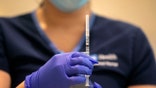 Nurse Eunice Lee prepares to give an injection of the Pfizer-BioNTech COVID-19 vaccine to a health care worker at Ronald Reagan UCLA Medical Center on Wednesday, Dec. 16, 2020 in Westwood, Calif. (Brian van der Brug/Los Angeles Times via AP, Pool)