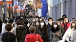 People wearing face masks to help curb the spread of the coronavirus walk on Aoyama shopping street in Tokyo Sunday, Dec. 27, 2020. Japan is barring entry of all nonresident foreign nationals as a precaution against a new and potentially more contagious coronavirus variant that has spread across Britain. The Foreign Ministry says the entry ban will start Monday and last through Jan. 31. (Yuka Ando/Kyodo News via AP)