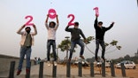 People hold cutouts to welcome the New Year in Ahmedabad, India, Thursday, Dec. 31, 2020. (AP Photo/Ajit Solanki)