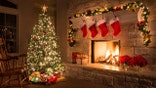 Glowing Christmas fireplace and living room, with tree, and stockings hanging from mantel by fireplace.Waiting for Santa.