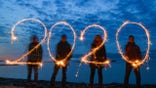 28 December 2019, Mecklenburg-Western Pomerania, Dranske: ILLUSTRATION - Four people write the year 2020 with sparklers into the evening sky at the stand of the Baltic Sea island of Rügen (shot with long time exposure). Photo: Patrick Pleul/dpa-Zentralbild/dpa (Photo by Patrick Pleul/picture alliance via Getty Images)