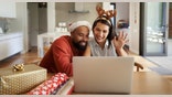 Shot of a happy young couple using a laptop during the Christmas holidays at home