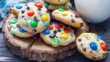 Shortbread cookies with multi-colored candy and chocolate chips on wooden board, horizontal