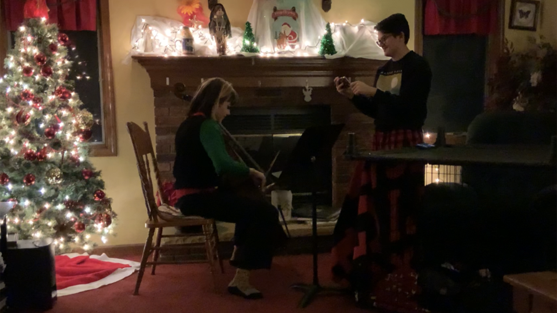 Bridget Brown playing cello for her schools virtual string Christmas concert. Her Brother Brody Brown video recording it to be played with all her band mates.
