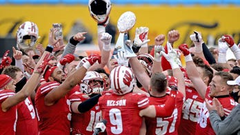 Wisconsin Badgers QB fumbles bowl-game trophy, smashing it on floor, videos show