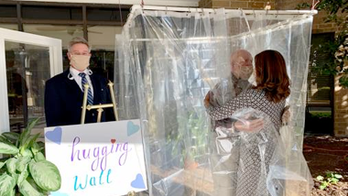 Virginia retirement community sets up hugging walls so family members can embrace