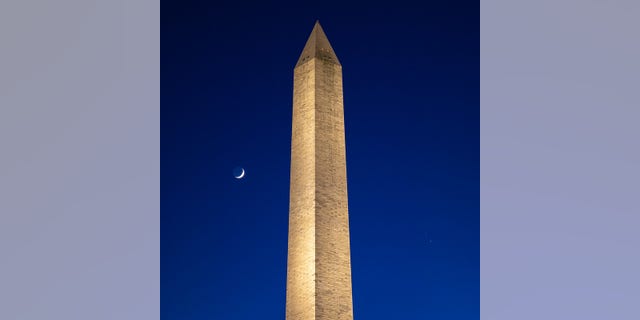 The Moon, left, Saturn, upper right, and Jupiter, lower right, are seen after sunset with the Washington Monument, Thurs. Dec. 17, 2020, in Washington. The two planets are drawing closer to each other in the sky as they head towards a "great conjunction" on December 21, where the two giant planets will appear a tenth of a degree apart. Photo Credit: (NASA/Bill Ingalls)
