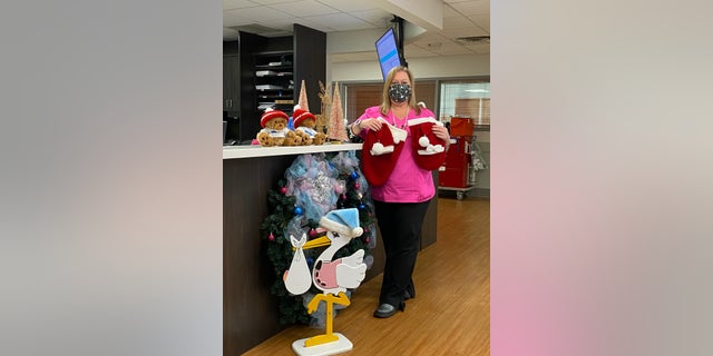 Nurse Lori Shaffer holding up some of the Christmas outfits that she and Pat Vicino made for newborn babies at St. Lucie Medical Center in Port St. Lucie, 플로리다.