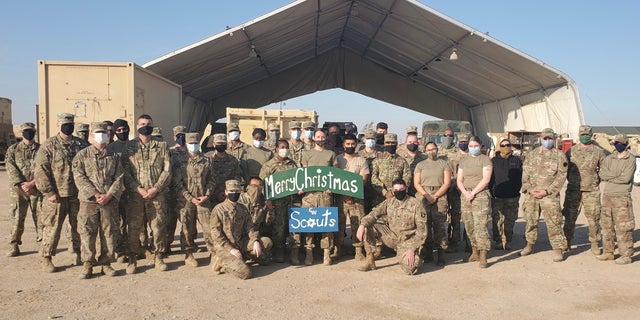 U.S. Soldiers with Headquarters Support Company, 628th Aviation Support Battalion, 28th Expeditionary Combat Aviation Brigade, pose for a photo at a motor pool in the 28th ECAB's area of operations in the Middle East. Spc. Anna Schmeck, an automated logistical specialist with HSC, made a sign for her students and colleagues at Conrad Weiser West Elementary School, where she works as a teacher.