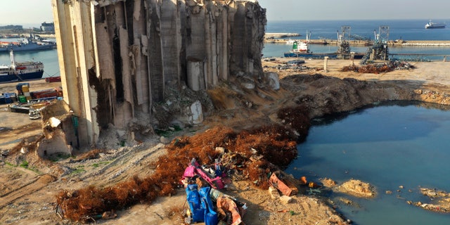 Rubble and debris remain around towering grain silos gutted in the massive August explosion at the Beirut port that claimed the lives of more than 200 people in Beirut, Lebanon, Wednesday, Dec. 2, 2020. A heated debate is underway in Lebanon over the fate of the towering silos with some arguing the gutted silos could collapse at any moment and must be demolished, while others call for the ruins to be preserved as a grim memorial. (AP Photo/Hussein Malla)