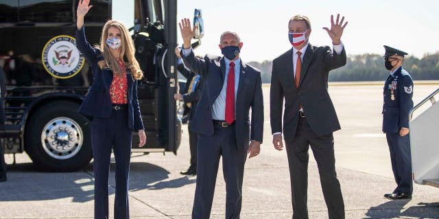 Visepresident Mike Pence, sentrum, Senator Kelly Loeffler, links, and Senator David Perdue, reg, wave at individuals at Dobbins Air Reserve Base in Marietta, Ga., Nov.. 20. (Alyssa Pointer /Atlanta Journal-Constitution via AP)