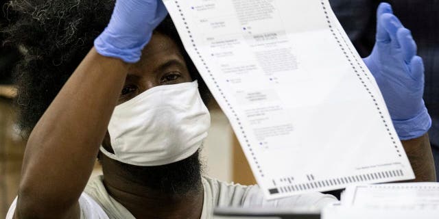 Workers scan ballots as the Fulton County presidential count kicks off Wednesday morning, November 25, 2020 at the Georgia World Congress Center in Atlanta.  (AP Photo / Ben Gray)