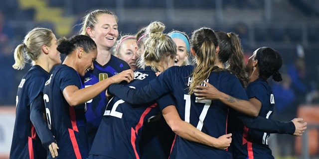 United States players celebrate with Kristie Mewis, number 22, who scored her side's second goal during the international friendly women's soccer match between The Netherlands and the US at the Rat Verlegh stadium in Breda, southern Netherlands, Friday Nov. 27, 2020. (Piroschka van de Wouw/Pool via AP)