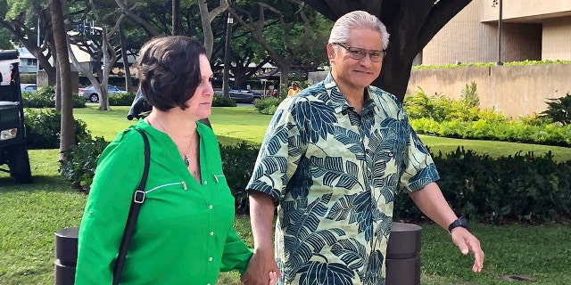 In this March 12, 2019, file photo, retired Honolulu police chief Louis Kealoha and his wife, former deputy city prosecutor Katherine Kealoha, hold hands while walking to U.S. district court in Honolulu. A once-respected, now-estranged power couple are scheduled to be sentenced Monday, Nov. 30, 2020, in Hawaii's biggest corruption case. A jury convicted Katherine and Louis Kealoha of conspiracy in a plot to frame her uncle to keep him from revealing fraud that financed their fancy lives. (AP Photo/Jennifer Sinco Kelleher, File)