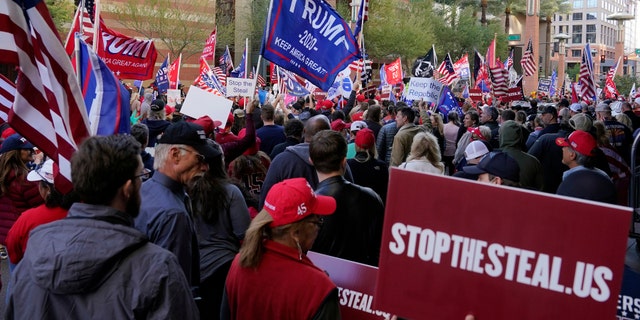 Supporters of President Donald Trump protest in front of a local hotel where Arizona Republicans have scheduled a meeting as a "fact-finding hearing" to discuss the election, featuring members of Trump's legal team and Arizona legislators, Monday, Nov. 30, 2020, in Phoenix. (AP Photo/Ross D. Franklin)