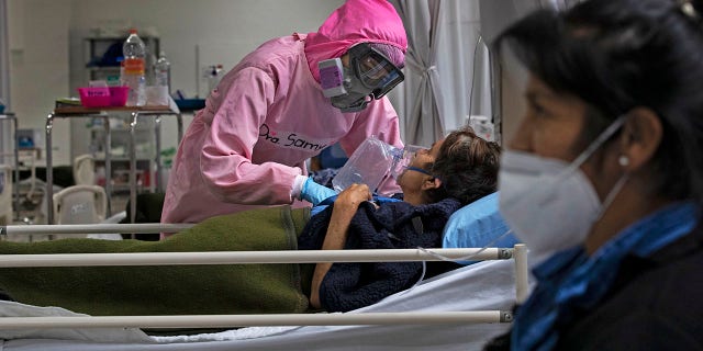 A health worker looks after patients at a military hospital set up for COVID-19 patients in Mexico City, Monday, Nov. 30, 2020. (AP Photo/Marco Ugarte)