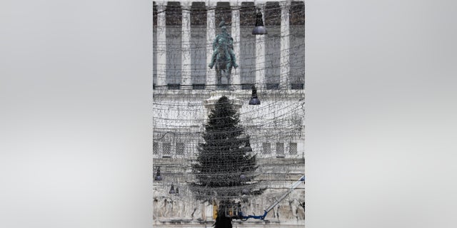 Turned off Christmas lights are backdropped by a 23mt (75 feet) tall fir tree placed in front of Rome's Unknown Soldier monument, Tuesday, Dec. 1, 2020. Still, the large number of daily new COVID-19 cases is worrying, Italian health experts said, especially with the approach of year-end holidays, which could prompt people to ignore social distancing rules and gather in large numbers to celebrate. (AP Photo/Gregorio Borgia)